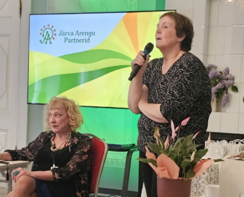 Maaeluvõrgustiku esindaja Ave Bremse esitamas küsimusi kunstnik Ave Nahkurile ja teleajakirjanik Maire Aunastele. Aruküla mõis, 3. juuni 2026. Foto: Krista Kõiv.